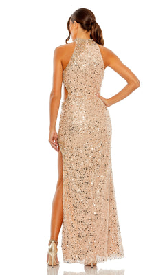 A woman stands with her back to the camera, wearing the Mac Duggal 49679 Cut-Out Long Sequin Formal Gown, featuring a high neckline, sleeveless design, backless cut and side slit.