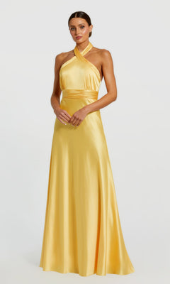A woman faces forward in a Mac Duggal 49728 long formal dress in lemon, featuring a halter neck and floor-length satin design, set against a plain light background.