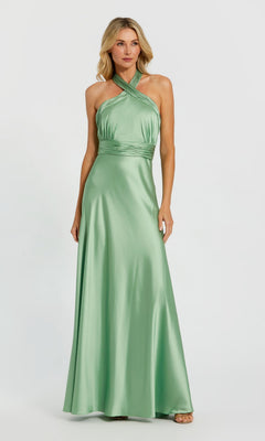 A woman in the Mac Duggal 49728 Long Formal Dress in sage, featuring a halter neck and fitted waist, stands against a plain light background.