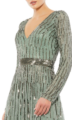 A person wears the Long Formal Dress 4977 by Mac Duggal, featuring long sleeves, a deep v-neckline, mint green color, vertical silver sequins, and a matching sequined waistband.