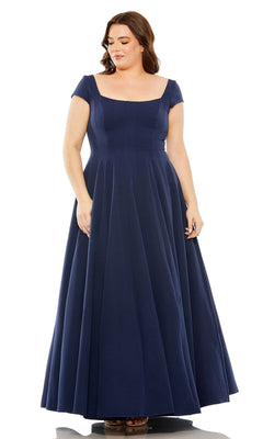 A woman in a Mac Duggal Plus-Size Simple Long Formal Dress 49783W, floor-length, navy blue, with short sleeves and a square neckline, stands against a white background.