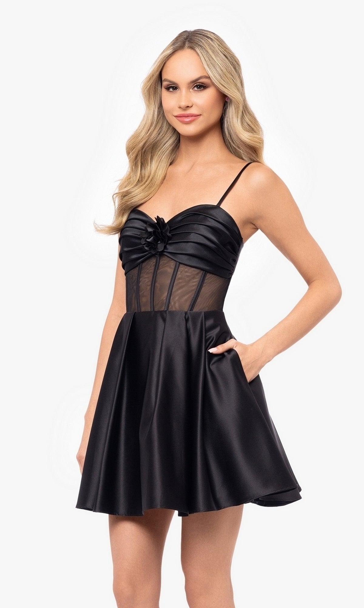 A woman models the Sheer-Bodice Short Black Hoco Dress 4982BN, featuring a lace-up design, fitted sheer corset-style bodice, and thin straps against a plain white background.