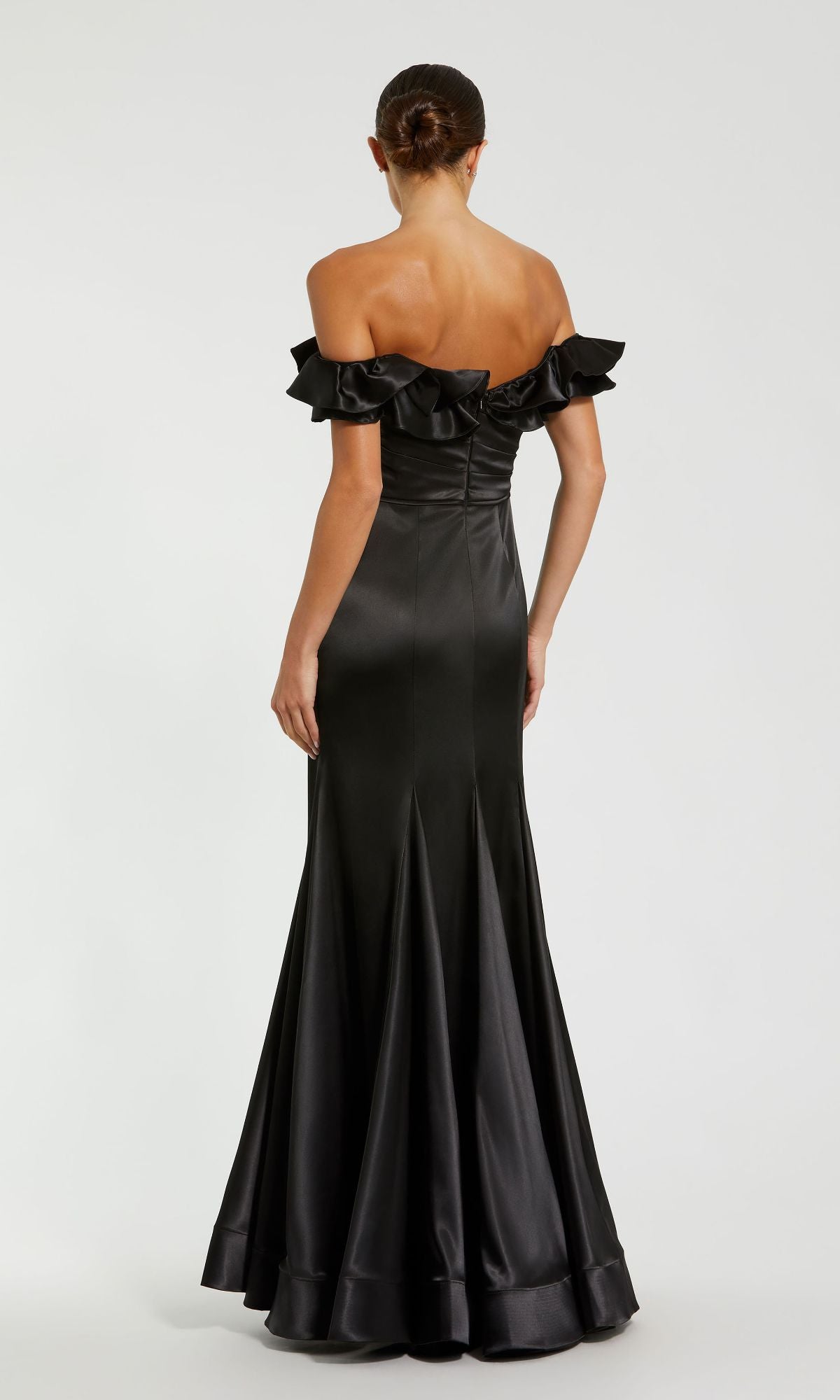 A woman faces away in the Mac Duggal 49834 Ruffled Long Satin Prom Dress, showcasing its ruffled off-the-shoulder neckline and fitted bodice of this elegant formal gown.