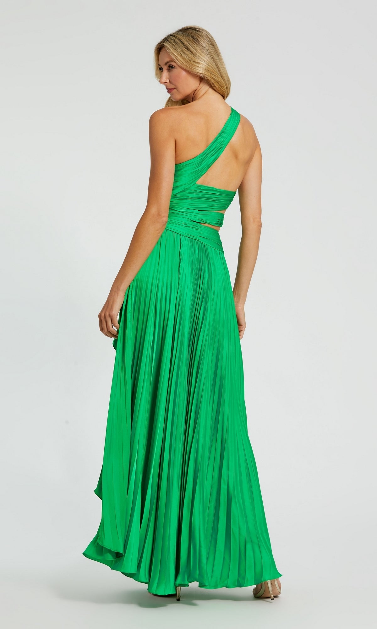 A woman in a vibrant green Mac Duggal 49837 High-Low Pleated Formal Dress stands facing away, looking over her shoulder.