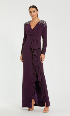 A woman wearing the Amethyst Purple Formal Gown (Mac Duggal 49897) with ruffle detailing and embellished shoulders stands against a plain background.