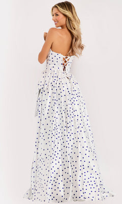 A woman in the Jovani 49899 long prom dress, featuring a strapless polka dot design and lace-up back, stands facing away, looking over her shoulder.