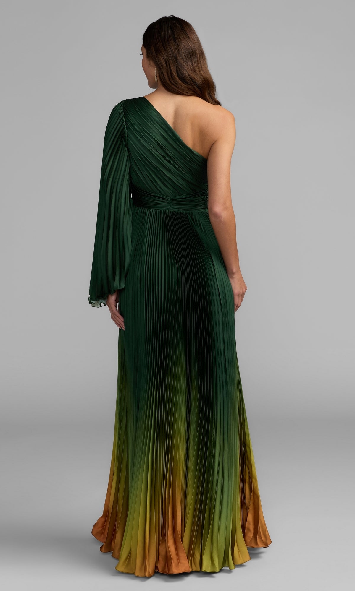 A woman faces away, elegantly dressed in the Mac Duggal 49903 One-Shoulder Ombre Formal Dress. The graceful pleated design showcases a stunning green, yellow, and orange gradient, and its sophisticated silhouette highlights the signature refinement of Mac Duggal eveningwear.