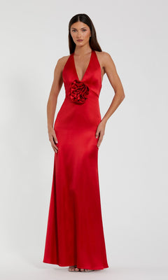 A woman stands against a plain white background wearing the Mac Duggal 49913 open-back long halter prom dress.