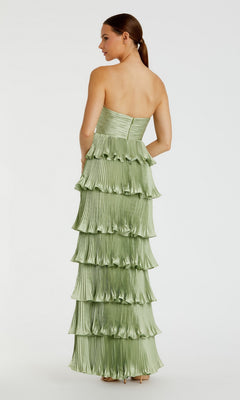 Woman in Mac Duggal 49981 Long Formal Dress—a floor-length, strapless light green gown with layered pleated ruffles—standing and facing away.