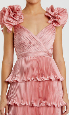 Woman wearing the Mac Duggal 49983 Long Formal Dress—a sleeveless pink gown featuring ruffled shoulder details and a tiered pleated skirt.
