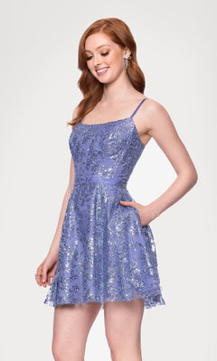 A woman with long red hair models the Blondie Nites 5001BN-1 Mini Glitter Hoco Dress, a sleeveless, short lavender cocktail dress with silver sequin spaghetti straps, standing against a plain white background.