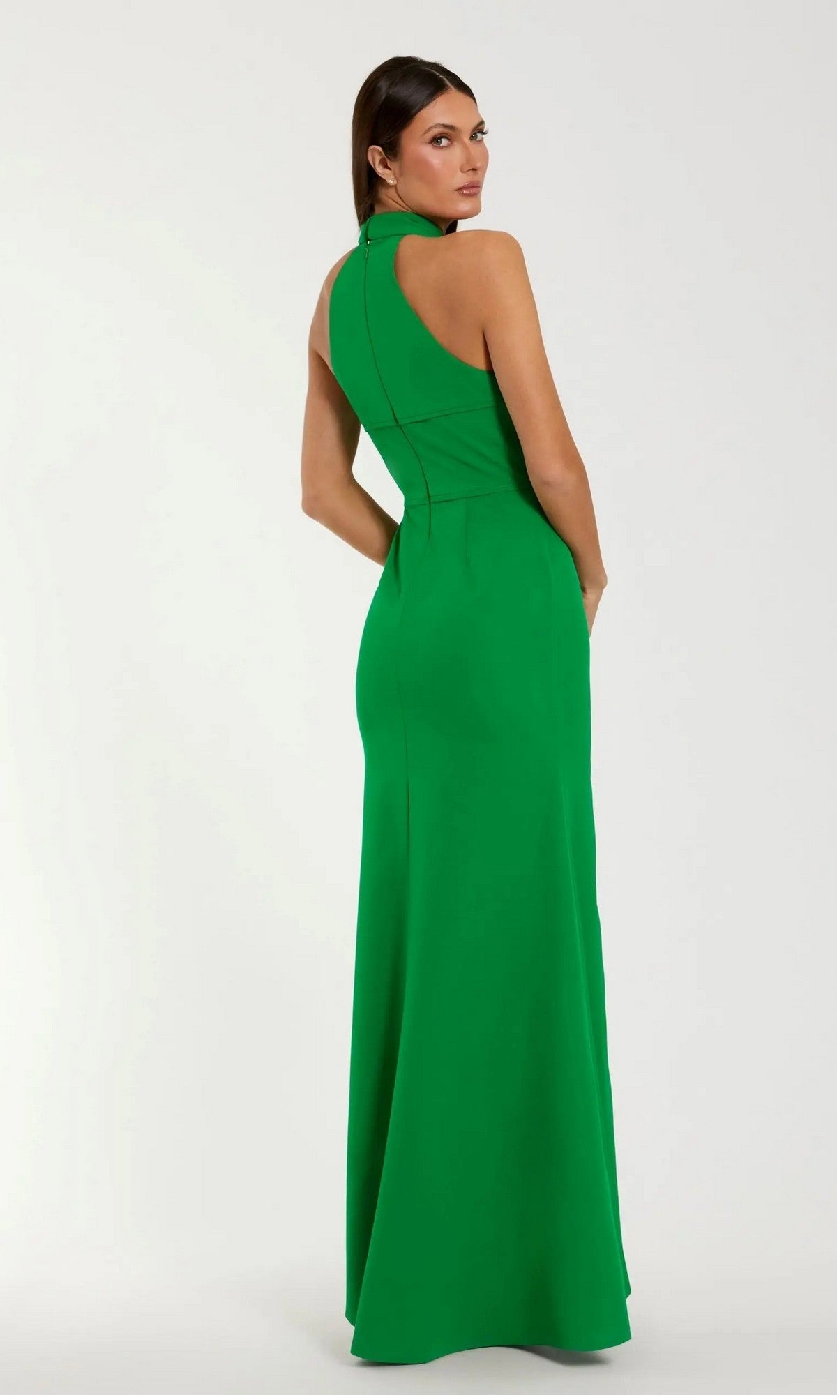 A woman faces away in a High-Neck Long Blue Formal Dress (Mac Duggal 50053) with a fitted waist and sleeveless design, standing against a plain light background.