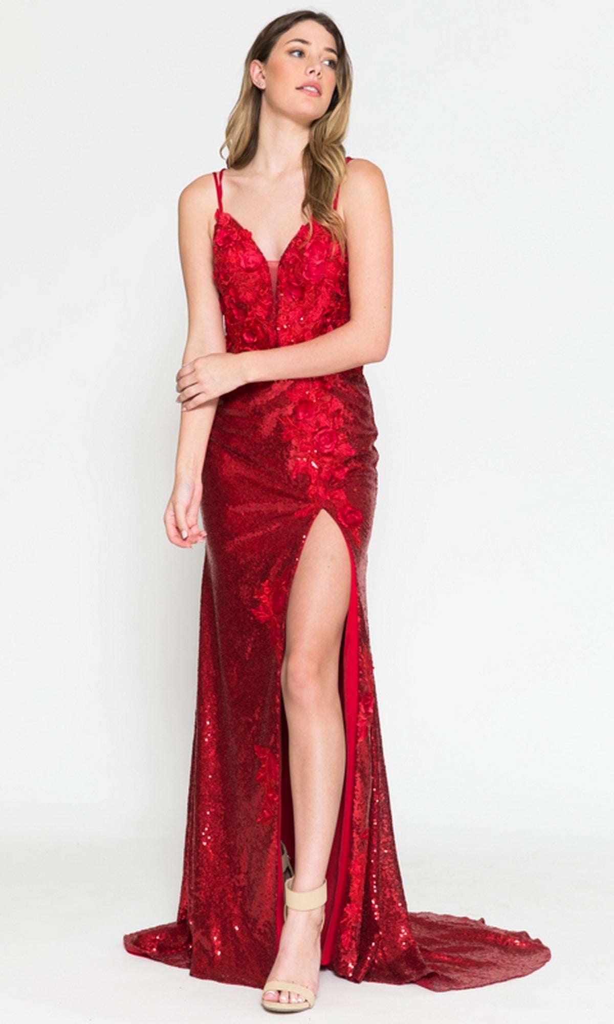 Woman in a Floral-Embellished Long Sequin Prom Dress 5020—floor-length, red with thigh-high slit, thin straps, open back, and beige high-heeled sandals—stands against a plain white background.