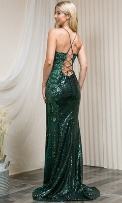 A woman wearing the Corset-Back High-Neck Long Sequin Prom Dress 5043 in dark green with a backless, crisscross strap design stands indoors on a wooden floor near a light-colored draped curtain.