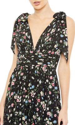 A woman wears the Mac Duggal Long Formal Dress 50657, featuring a sleeveless floral print, deep V-neck, shoulder tie straps, and an elegant A-line silhouette.