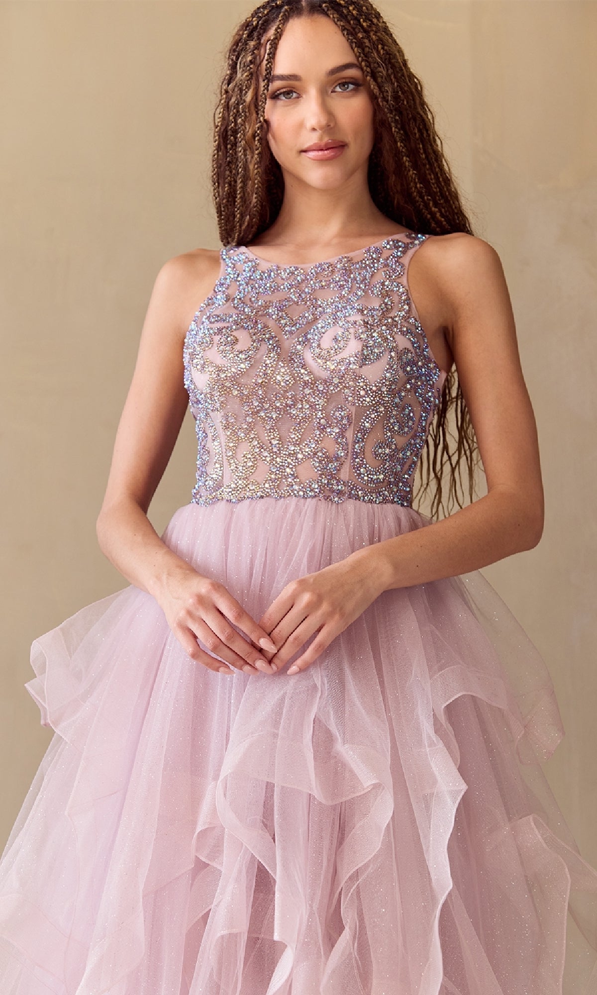 Woman wearing a pink dress with sequined bodice against a beige background