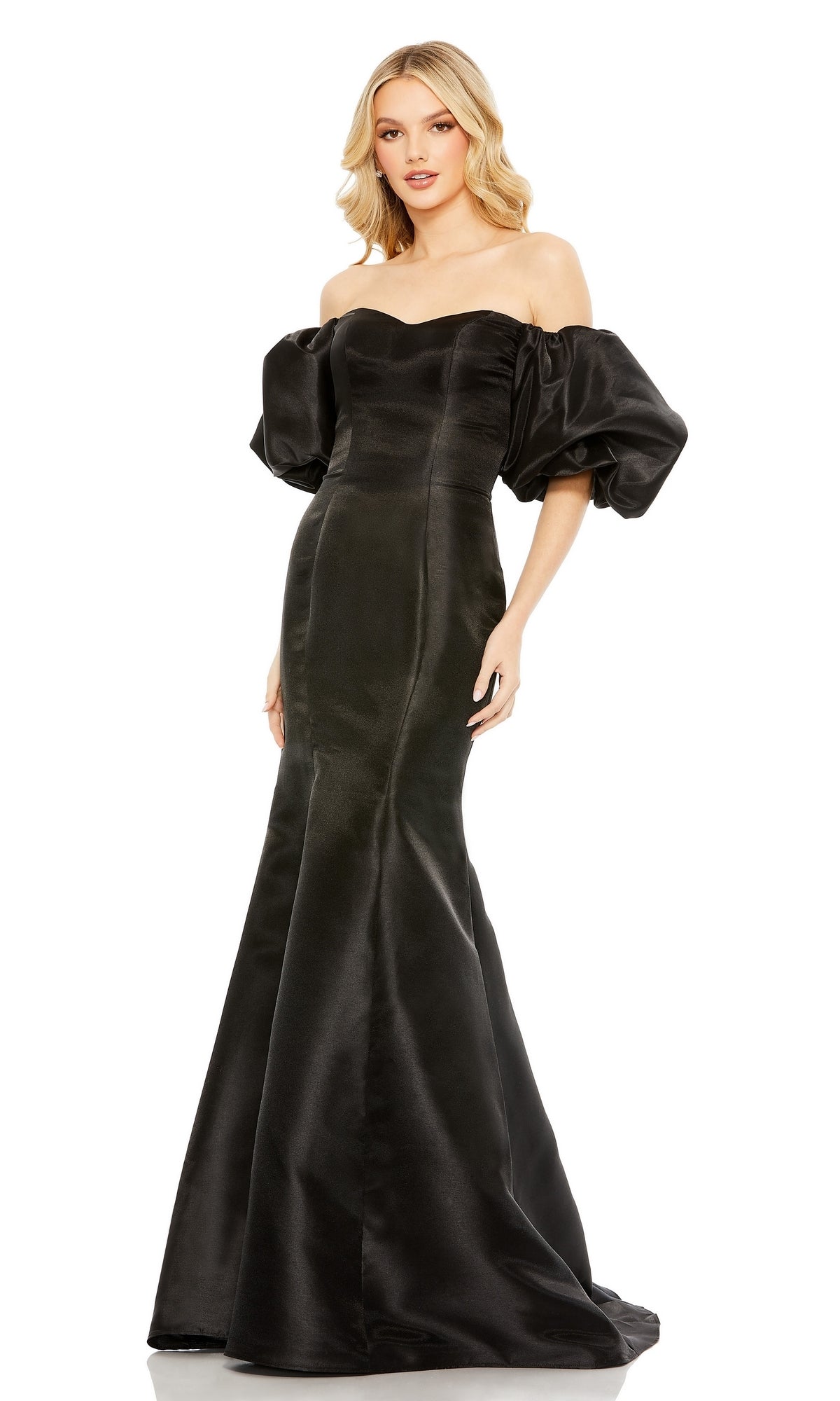 A woman stands facing forward in the Mac Duggal 50677 Off-the-Shoulder Long Gala Gown, a floor-length black mermaid dress with puffed short sleeves.