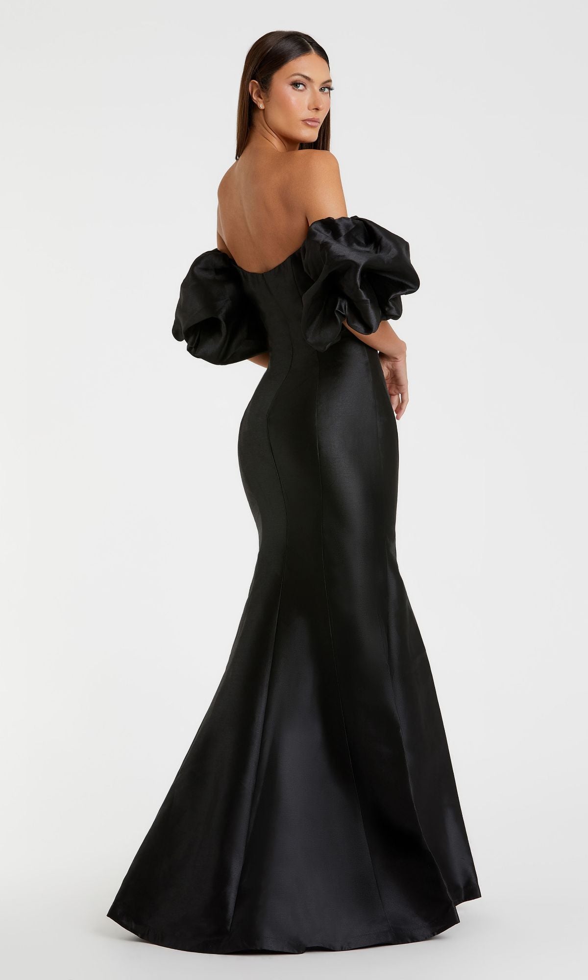 A woman poses against a plain white background in the Mac Duggal 50677 Off-the-Shoulder Long Gala Gown, a black mermaid-style dress featuring dramatic puff sleeves.