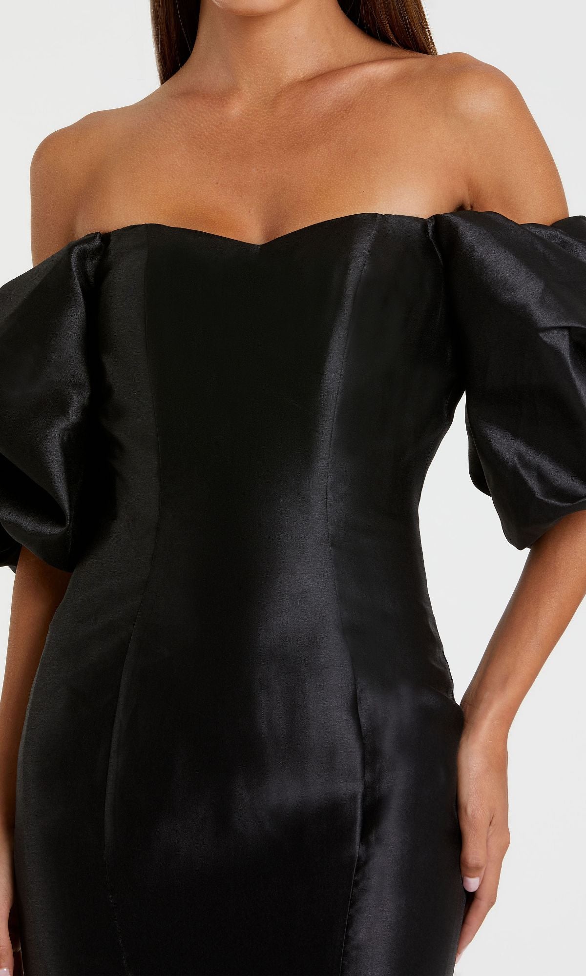 Woman wearing the Off-the-Shoulder Long Gala Gown: Mac Duggal 50677—an elegant black mermaid dress with puffed short sleeves, a fitted bodice, and smooth satin-like fabric.