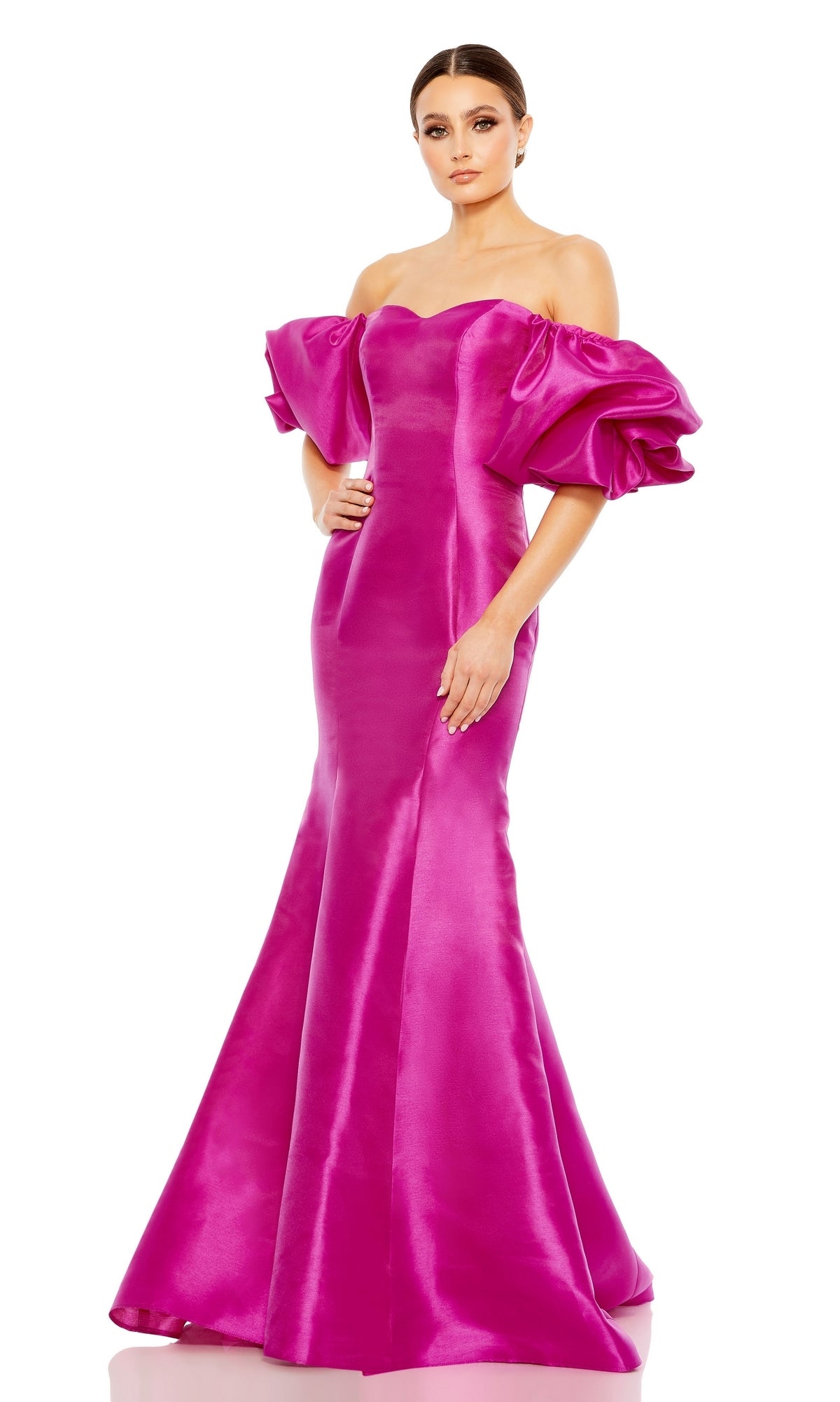 A woman stands against a white background in the Off-the-Shoulder Long Gala Gown: Mac Duggal 50677—a bright pink, floor-length mermaid dress featuring dramatic puff sleeves.