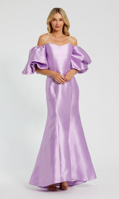 A woman stands against a plain light background wearing the Mac Duggal 50677 Off-the-Shoulder Long Gala Gown in lavender, featuring a floor-length mermaid silhouette and large puff sleeves.