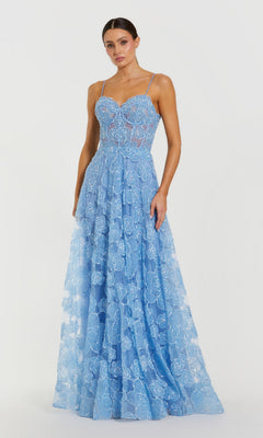 A woman wears the Mac Duggal 50735 Long Formal Dress in powder blue, a floor-length, sleeveless lace gown with thin straps and a floral pattern, standing against a plain white background.