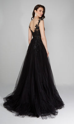 Wearing the Alyce 5090 long formal dress, a woman poses against a plain gray background in a black lace embroidered gown featuring a deep V-back and an elegant A-line tulle skirt.
