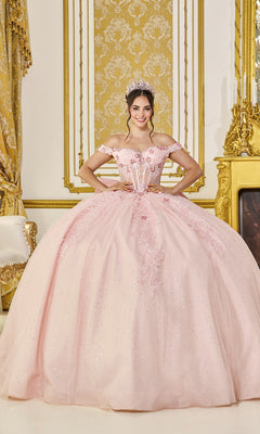 A young woman in the Quinceanera Dress 5090 by Dancing Queen, blush color, with glitter tulle and off-the-shoulder design, smiles in an ornate gold-decorated room while wearing a tiara.