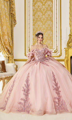 A young woman in a jeweled tiara wears the blush Quinceanera Dress 5106 by Dancing Queen, standing in an ornate, gold-accented room filled with elaborate decor.