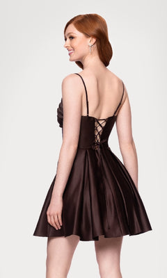 A woman stands smiling, facing away from the camera, in an affordable dark brown Blondie Nites 5107BN Lace-Up Short Hoco Dress featuring a sleeveless design and lace-up back.