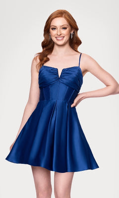 A red-haired woman models the affordable Blondie Nites 5107BN Lace-Up Short Hoco Dress—a sleeveless deep blue satin gown with spaghetti straps—standing before a plain light background.