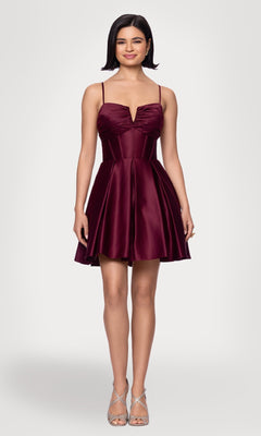 A woman faces forward in the Blondie Nites 5107BN Lace-Up Short Hoco Dress, a sleeveless burgundy satin corset homecoming dress with a fitted bodice and flared skirt, paired with silver high heels.