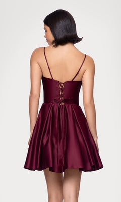 A woman with short dark hair models the Blondie Nites 5107BN—a sleeveless, maroon lace-up back Hoco dress with thin straps—showing off an elegant and affordable party look from behind.
