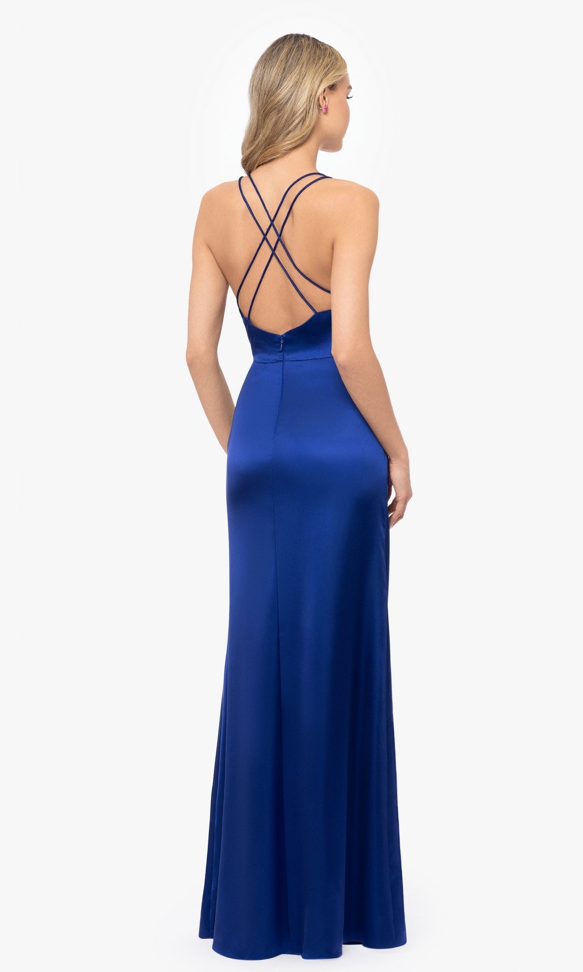 A woman wearing the Long Stretch Satin Prom Dress: Blondie Nites 5119N in royal blue, featuring a fitted silhouette and crisscross straps on the open back, stands against a plain white background.