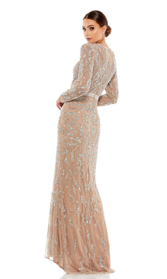 A woman faces away, wearing the Mac Duggal 5124 Long Sleeve Sequin Formal Dress with silver embellishments and long sleeves, her hair styled in a low bun.