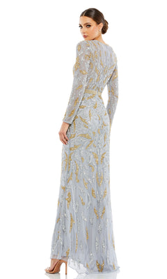 A woman stands looking over her shoulder, wearing the Mac Duggal 5124 Long Sleeve Sequin Formal Dress—floor-length with silver and gold sequins—styled elegantly with high-heeled sandals.