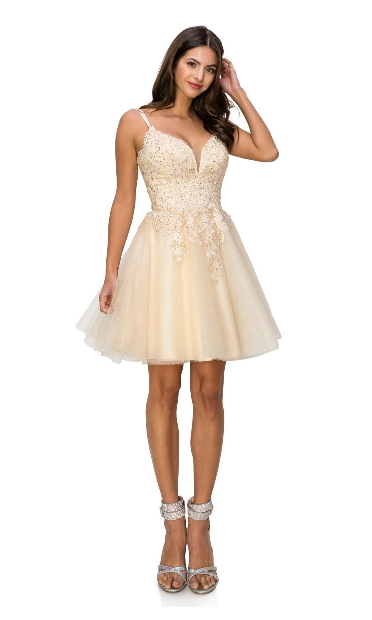 Woman in heels models the Corset-Back Short Glitter Homecoming Dress 5125J, a cream sleeveless A-line dress with a fitted bodice, lace details, and tulle skirt, standing against a white background.