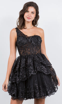 A woman stands against a plain background wearing the One-Shoulder Short Tiered Homecoming Dress 5132J, featuring black sparkly lace, a fitted bodice, and layered details.