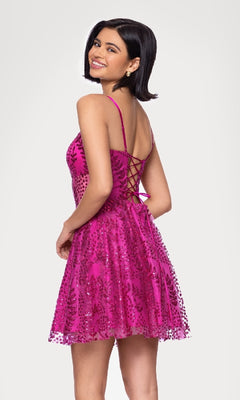 A woman smiles, turned slightly to the side, wearing the Blondie Nites 5153BN—a short glitter hoco dress in pink with sequins and a sleeveless lace-up back design.