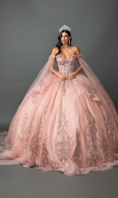 A woman wears the Quinceanera Dress 5158 by Dancing Queen in rose gold, featuring an ornate tulle ballgown skirt and an intricately embroidered corset bodice, accessorized with a tiara as she stands against a plain gray background.