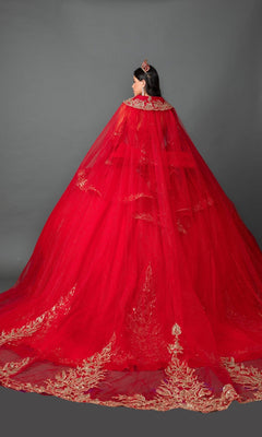 A woman stands facing away against a plain gray background, wearing the Quinceanera Dress 5161 By Dancing Queen—a red strapless ballgown featuring gold embroidered appliques and a long train—and a matching red crown.