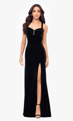 A woman stands facing forward in the Simple Long Velvet Prom Dress, Blondie Nites 5171BN—a black gown with a front slit, wide straps, and a sweetheart neckline.