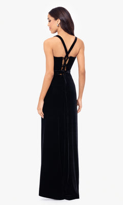 A woman models the Simple Long Velvet Prom Dress (Blondie Nites 5171BN)—a sleeveless black gown with crisscross straps and lace-up back—against a white background.