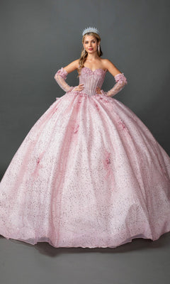 A woman stands with hands on hips, wearing the Quinceanera Dress 5173 by Dancing Queen in a sparkling blush hue, featuring a beaded corset bodice and long gloves, topped off with a tiara, against a plain gray background.