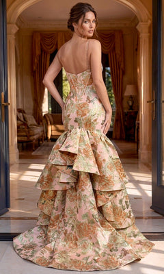 A woman wearing the elegant Jovani 52175 long formal dress stands in an opulent room, looking over her shoulder. The dress features a stunning floral corset bodice with delicate ruffles and thin straps.