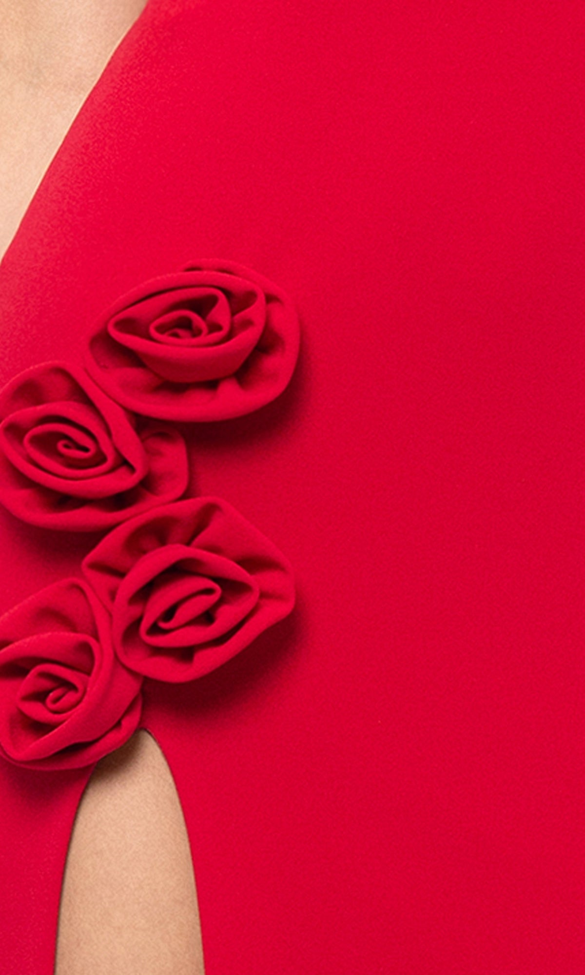 Close-up of the Rosette Long Red Prom Dress by Blondie Nites 5218BN, featuring three fabric roses and an elegant opening that subtly reveals light skin beneath the formal material.