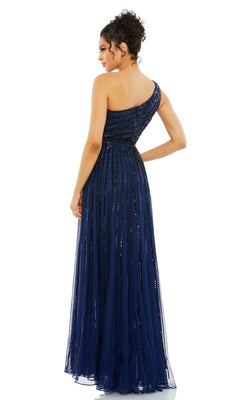 A woman faces away in the Mac Duggal 5220 One-Shoulder Beaded Formal Dress, a navy blue A-line evening gown featuring a fitted bodice, flowing skirt, and subtle sequin embellishments.