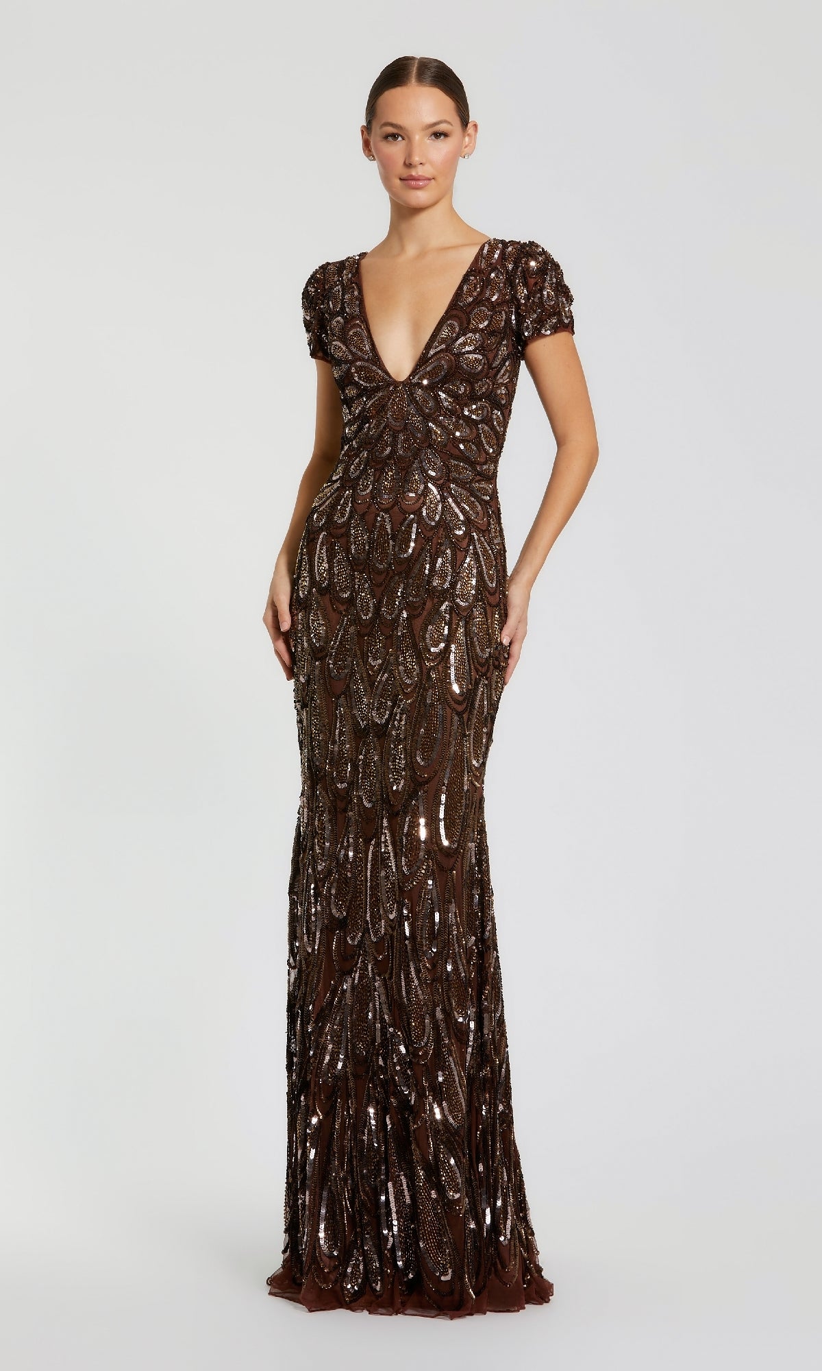 Woman wearing a long, dark brown sequin dress on a white background