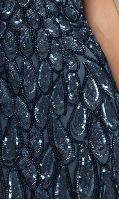 Close-up of dark blue fabric adorned with sequins and bead embellishments in a teardrop pattern, echoing the intricate detailing featured on the Sequin Long Brown Formal Dress: Mac Duggal 5243; a person’s arm is visible on the right.