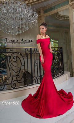 A woman poses by a black railing under a chandelier wearing the Off-Shoulder Long Prom Dress: Jessica Angel 528.